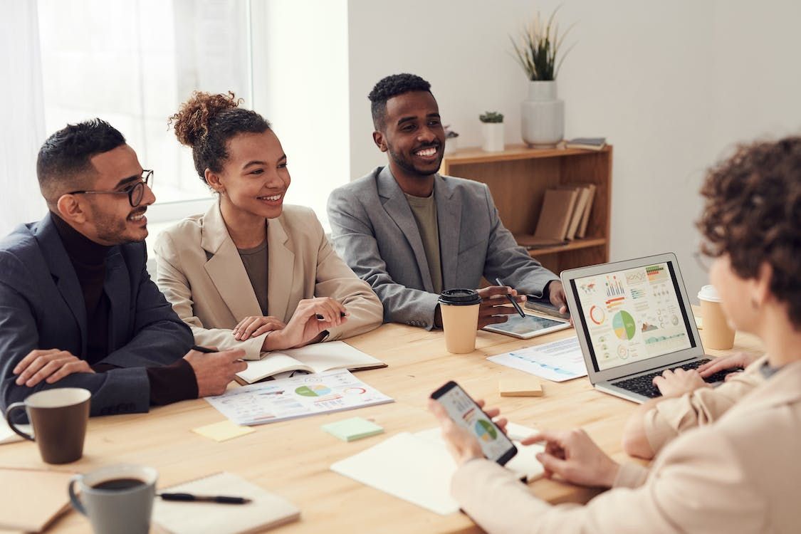 Un equipo de trabajadores híbridos usando inteligencia artificial para traducción en la oficina